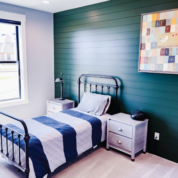 A farmhouse inspired bedroom with a twin bed cover in a striped duvet