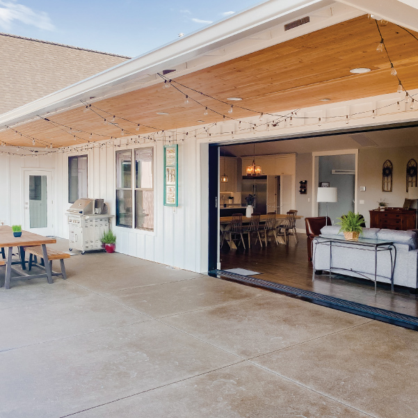 View into living area from the patio of the Farmhouse Luxury custom home built by Mike Riddle Construction