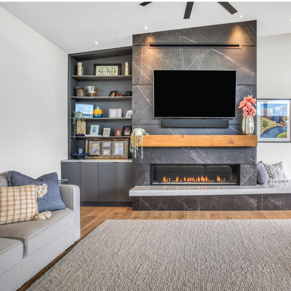 Modern home living room featuring a gray-tiled fireplace with TV built by Mike Riddle Construction