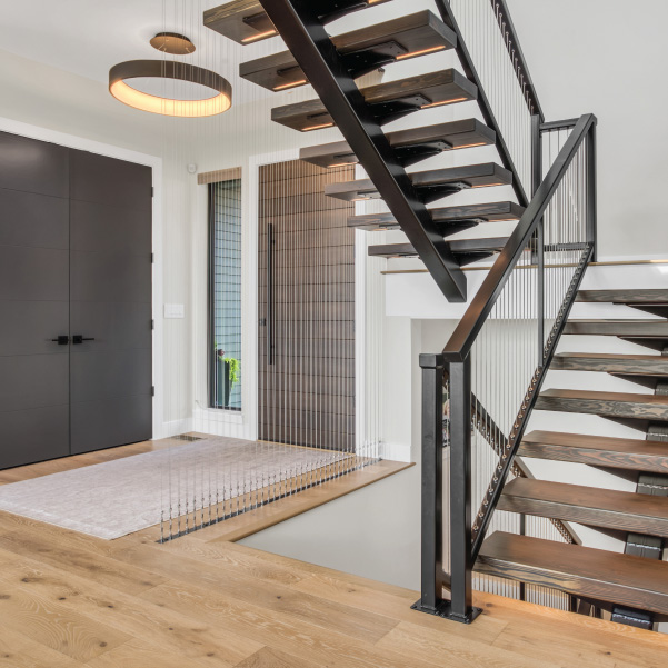 Front entry with a steel staircase in a custom home built by Mike Riddle Construction