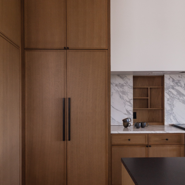 A full-size refrigerator faced with cabinet doors in the Lagom home built by Mike Riddle Construction