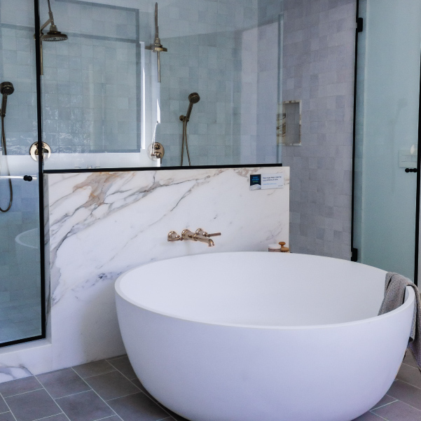 White round soaking tub and walk-in shower for a bathroom in an organic modern style built by Mike Riddle Construction