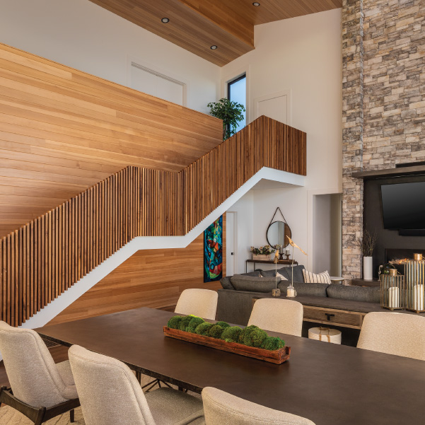 Modern wood staircase overlooking living area of coastal home built by Mike Riddle Construction