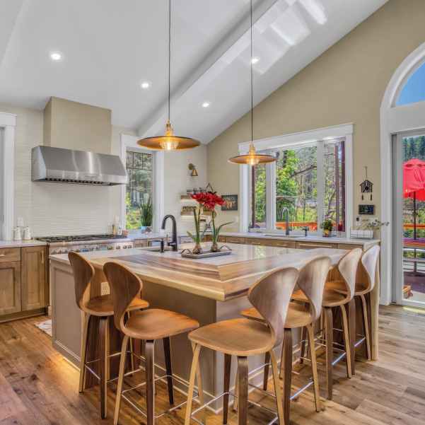 A kitchen island with stools in a rustic modern home built by Mike Riddle Construction