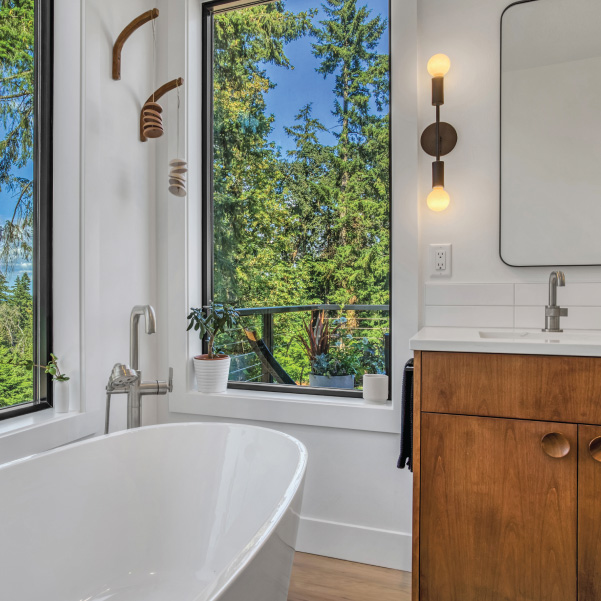 Bathtub and vanity sink next to bathroom window